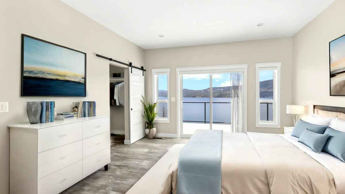 A serene bedroom featuring a picturesque view of a tranquil lake surrounded by majestic mountains